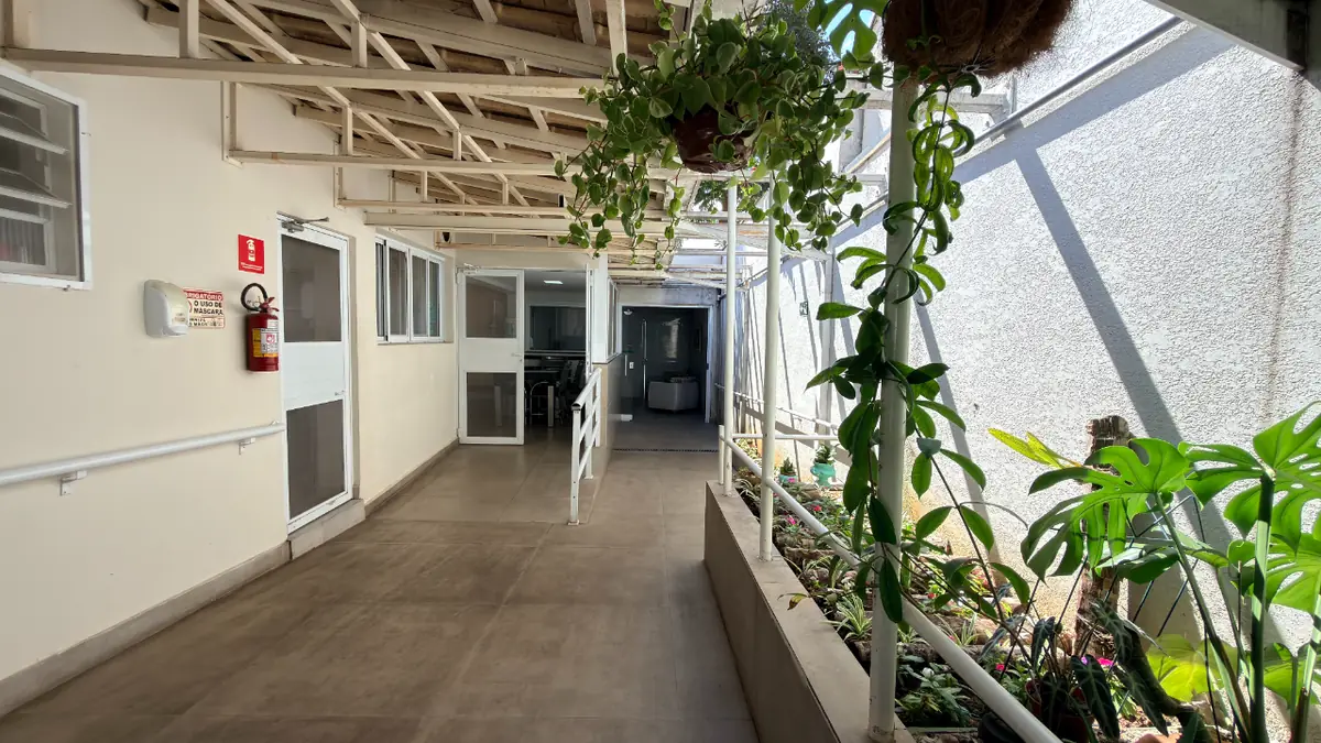 Corredor com plantas e jardim lateral no Residencial Veneza,