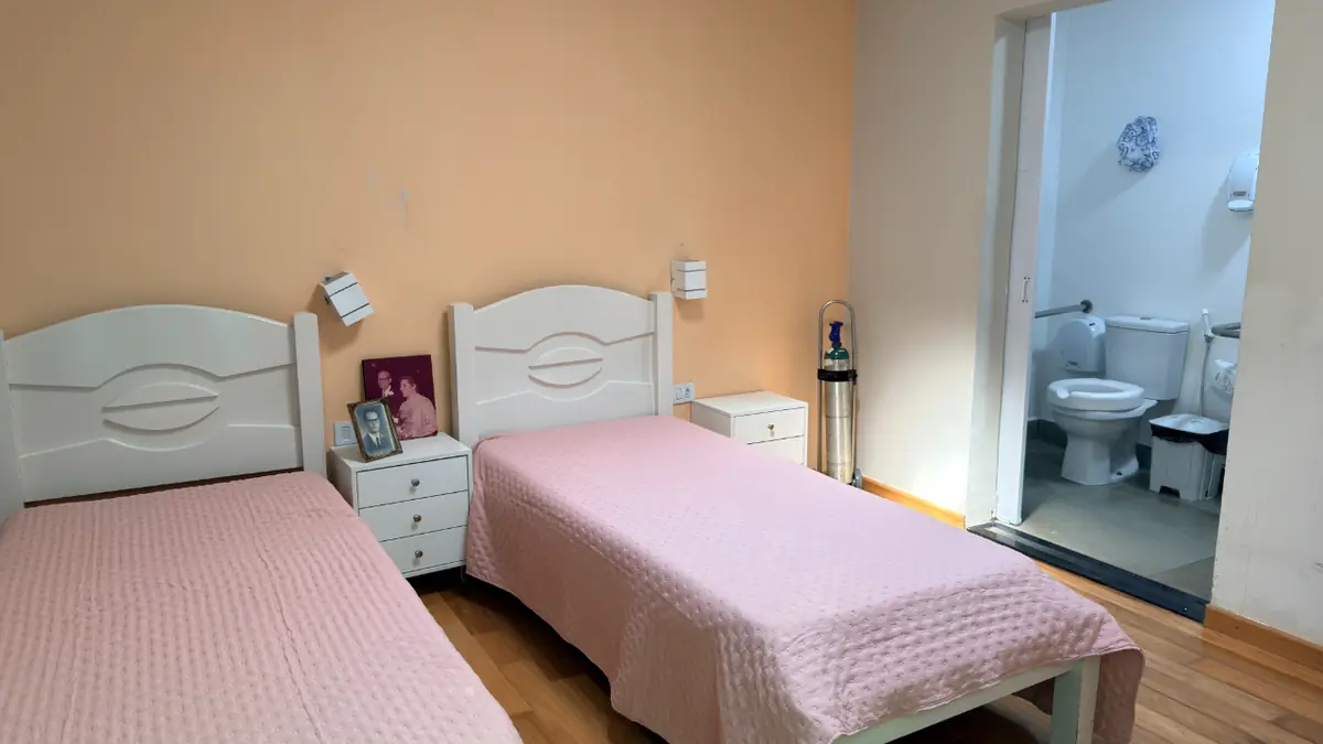 Quarto com duas camas, criado-mudo e banheiro adaptado no Residencial Veneza, casa de repouso em SP