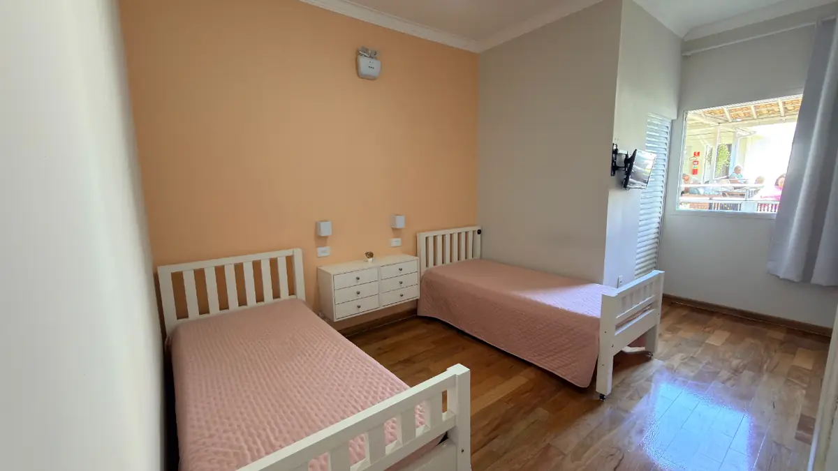 Quarto individual com cama de madeira e criado-mudo no Residencial Veneza, Alto da Lapa
