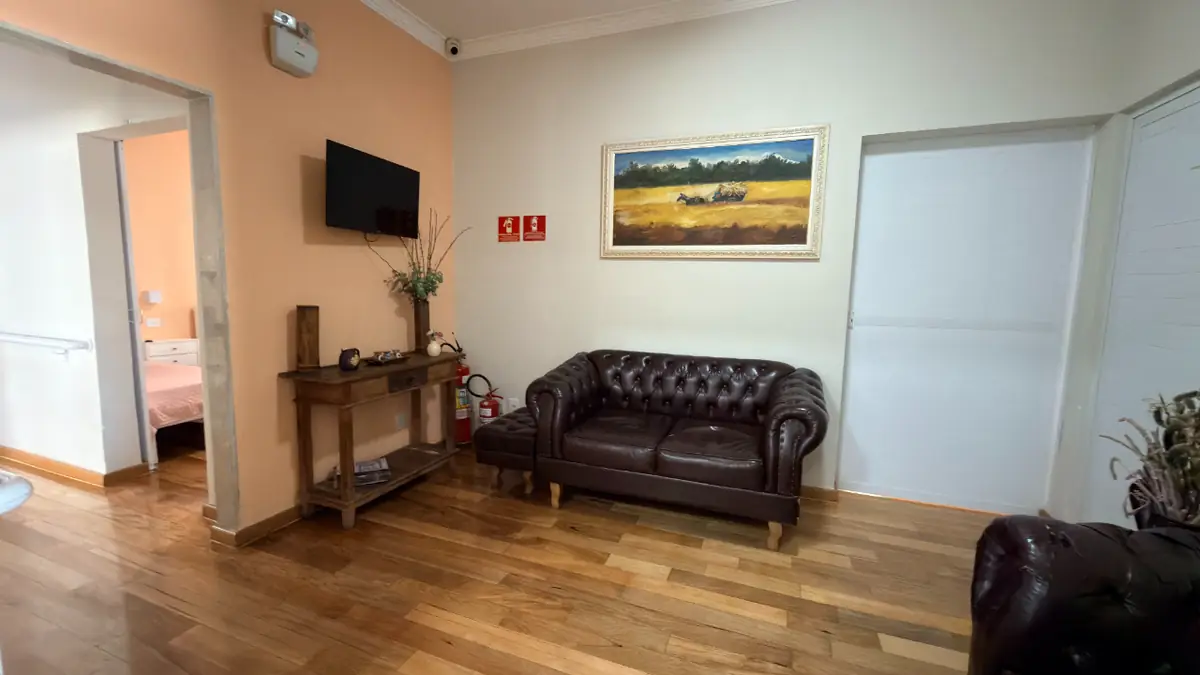 Recepção com sofá de couro e quadro no Residencial Veneza, casa de repouso em SP